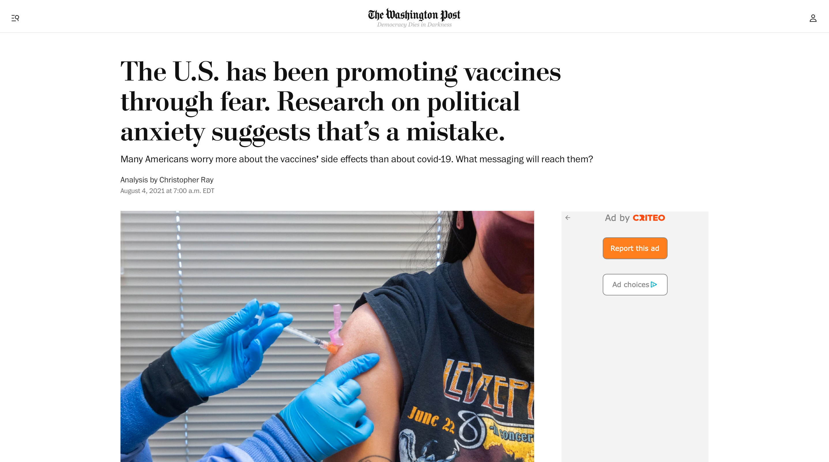 Screenshot of Washington Post headline and article by Christopher Ray. Headline says "The U.S. has been promoting vaccines through fear. Research on political anxiety suggests that’s a mistake." above a photo of a medical provider wearing blue latex gloves and administering a Covid-19 vaccine to a person wearing a cloth mask and a Led Zeppelin t-shirt.